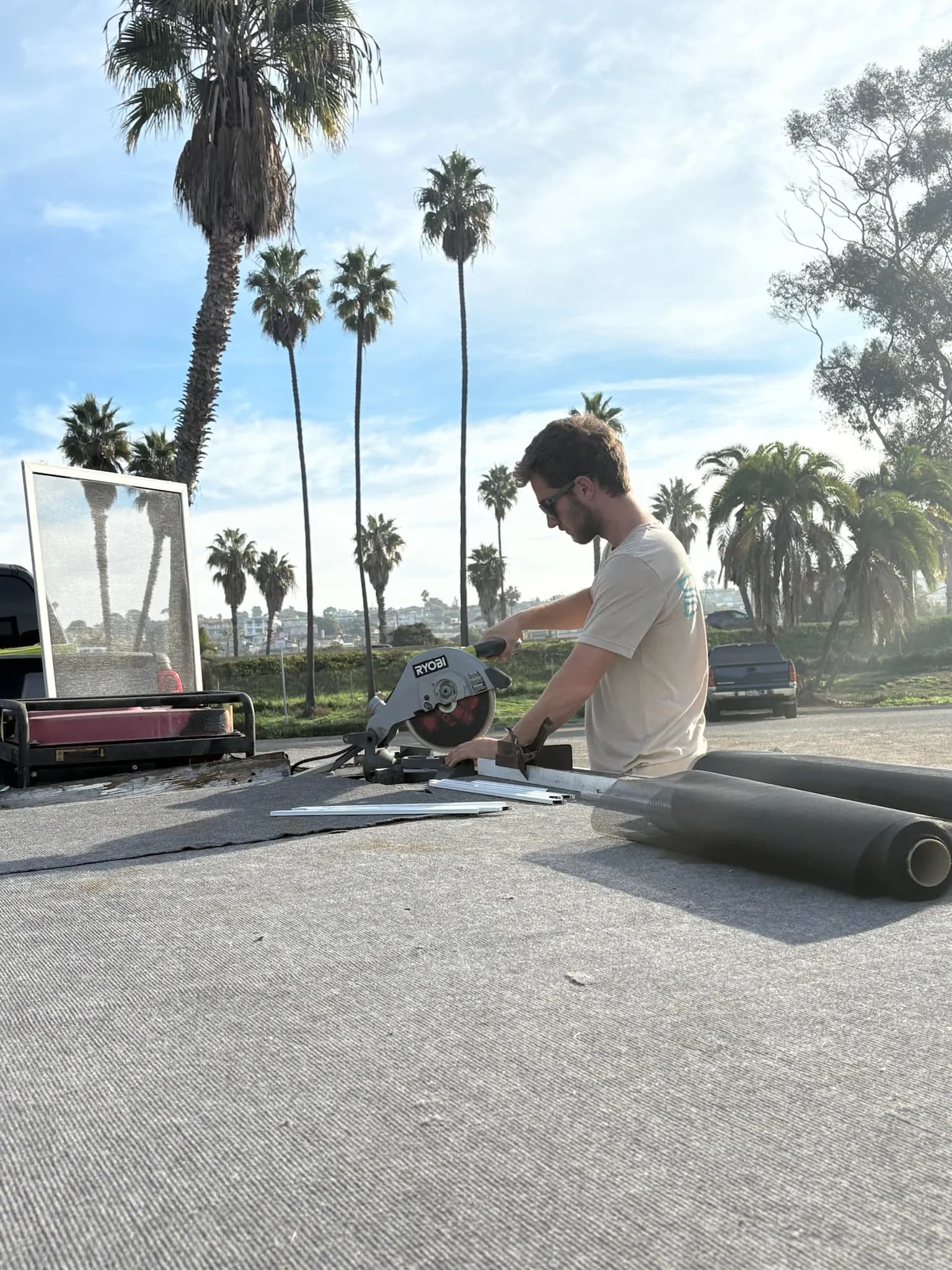 Technician cutting screen frame with a miter saw outdoors in San Diego