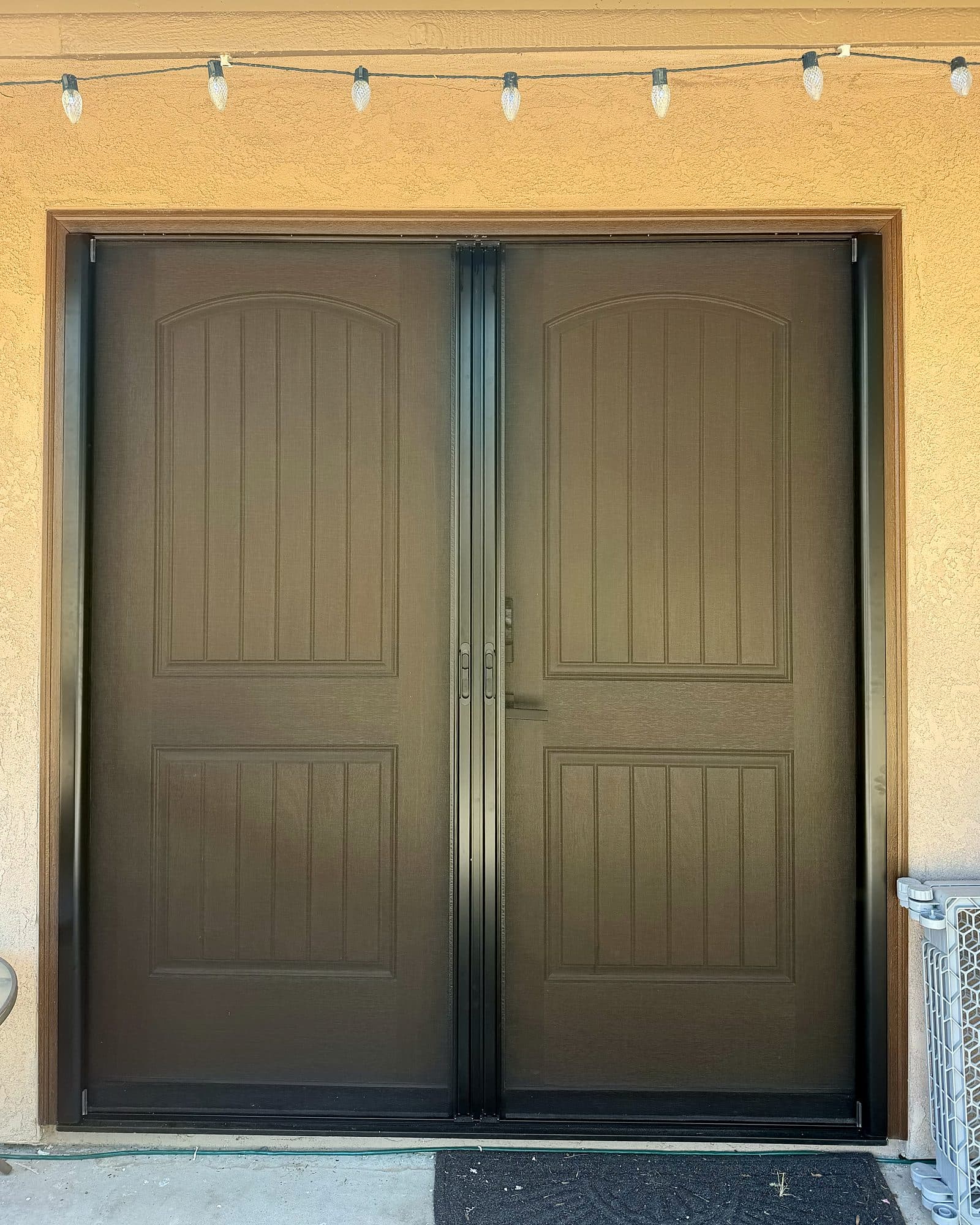 Retractable screens closed across a brown double front door, French set