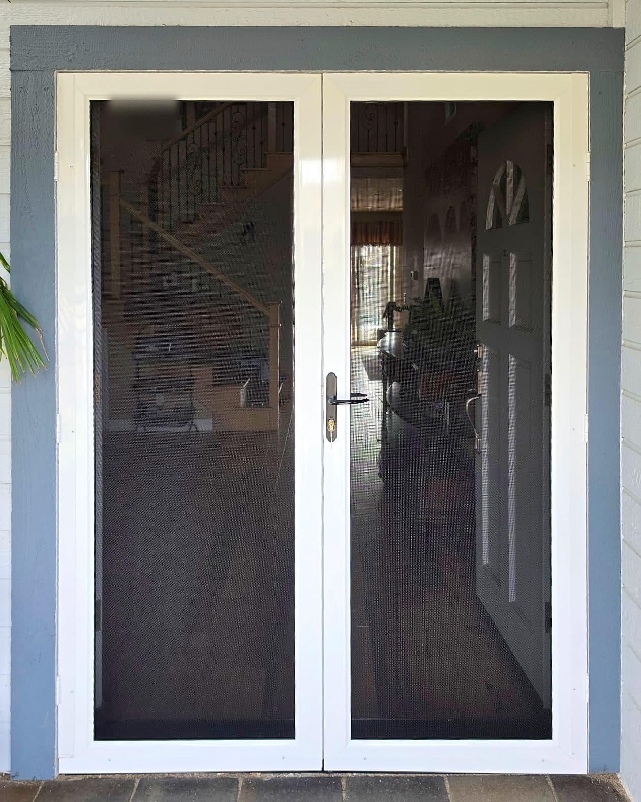 White Tru-View screen doors as a French pair, closed, on a gray front entry
