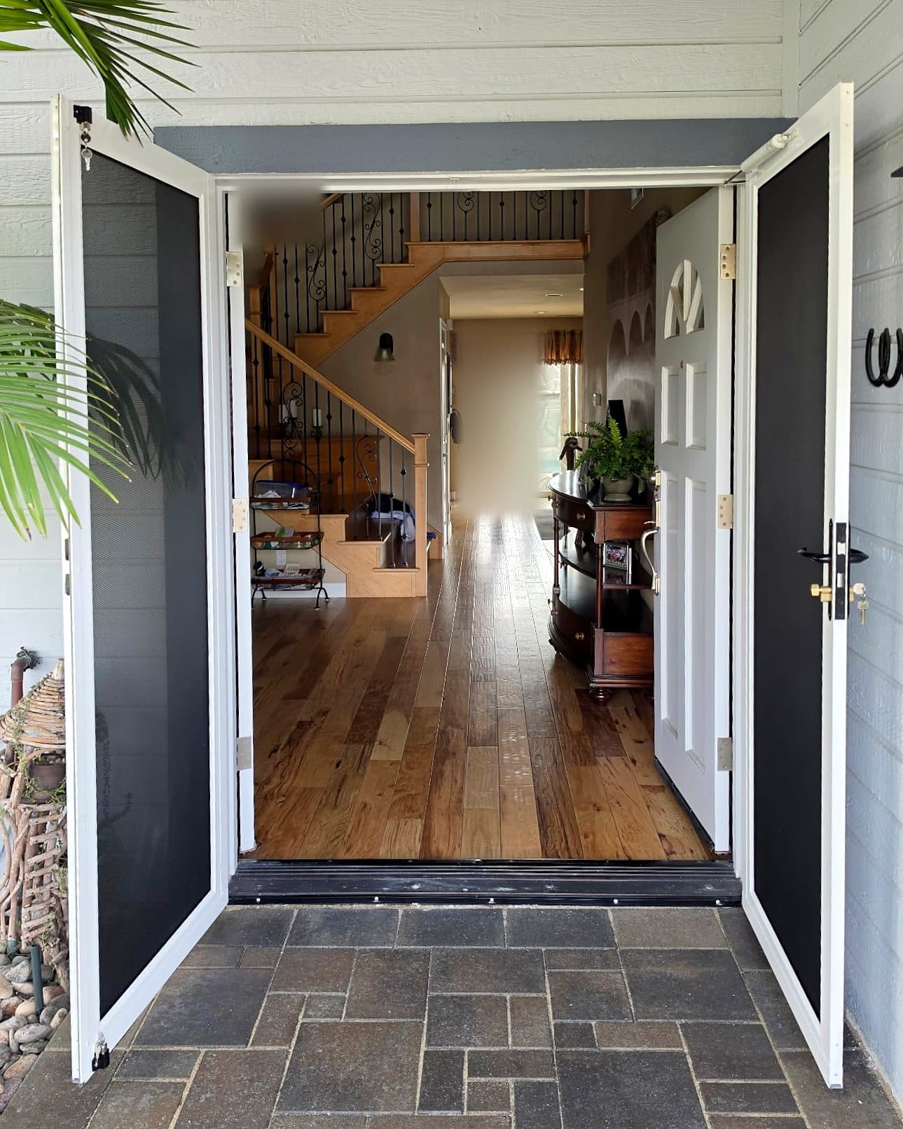 White Tru-View French screen doors swung open on a front entry with a view down the hallway