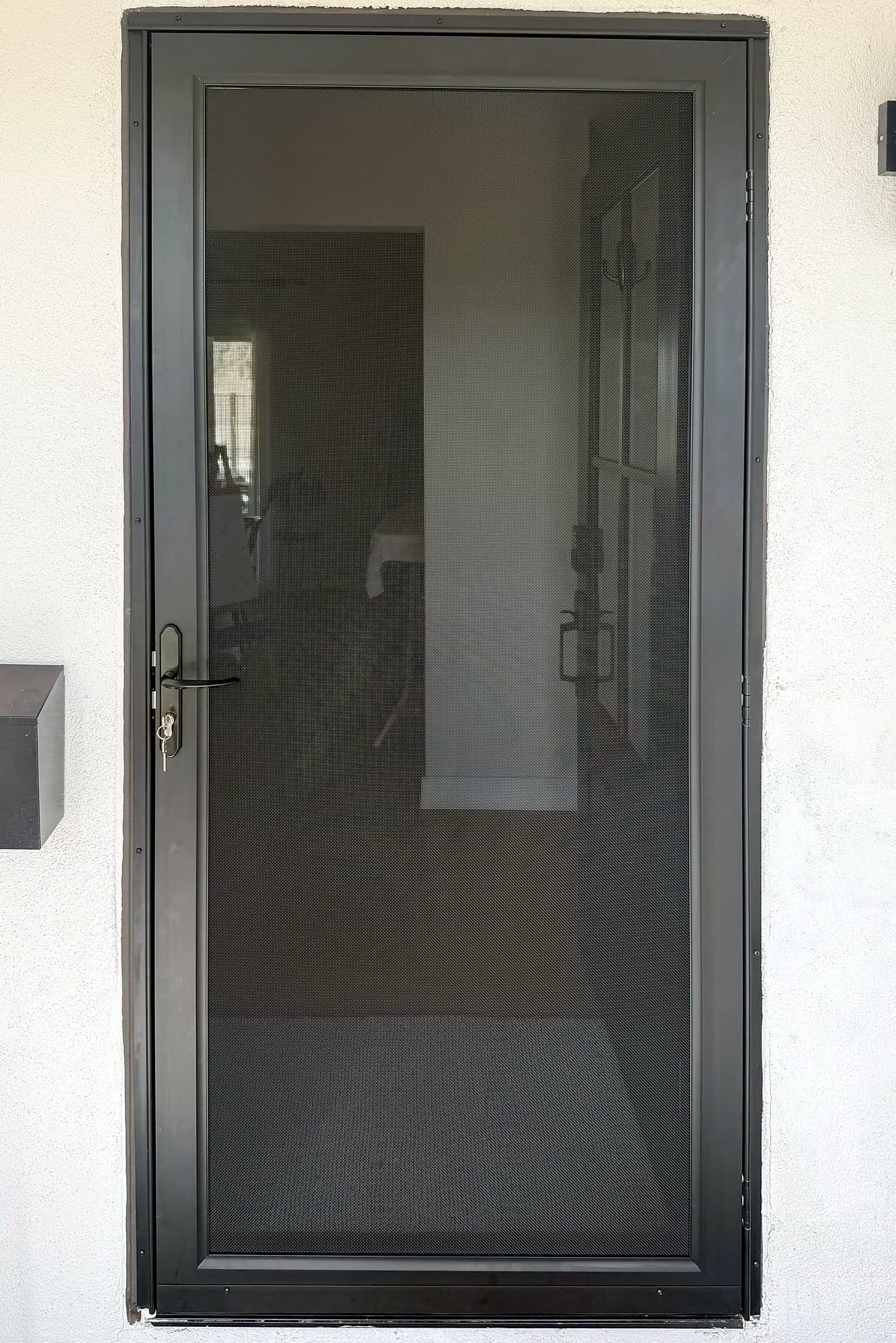 Black Tru-View security screen door on a white stucco front entry