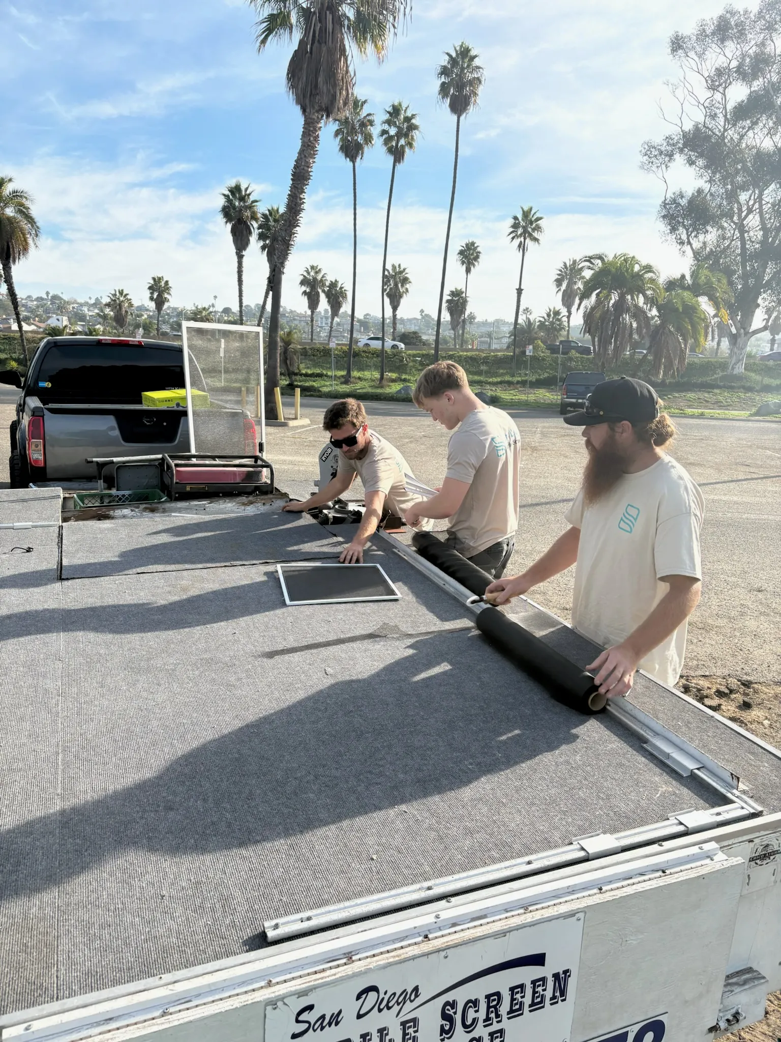 Technicians building a custom screen on the mobile workshop trailer
